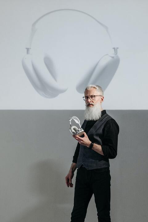 a-man-standing-in-front-of-a-projection-holding-headphones