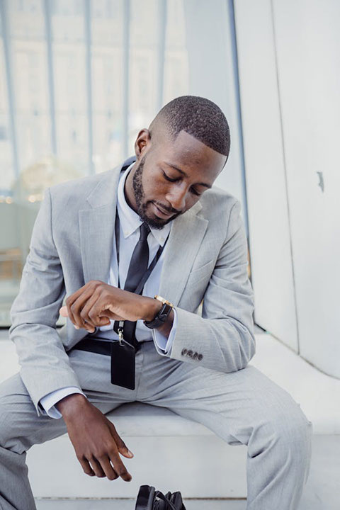 elegant-office-worker-wearing-a-suit-sitting-and-looking-at-his-watch