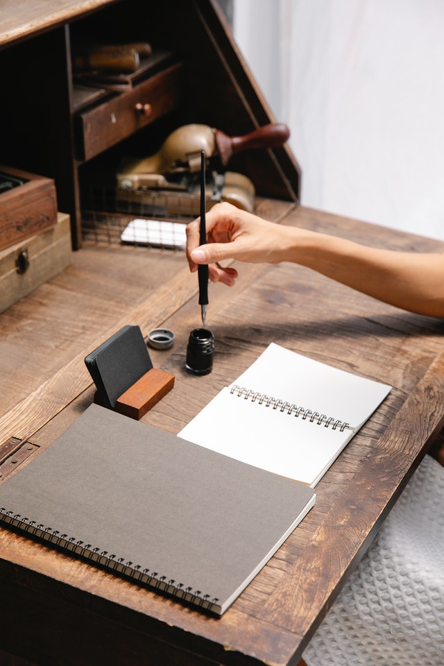 crop-faceless-woman-dipping-pen-in-inkwell